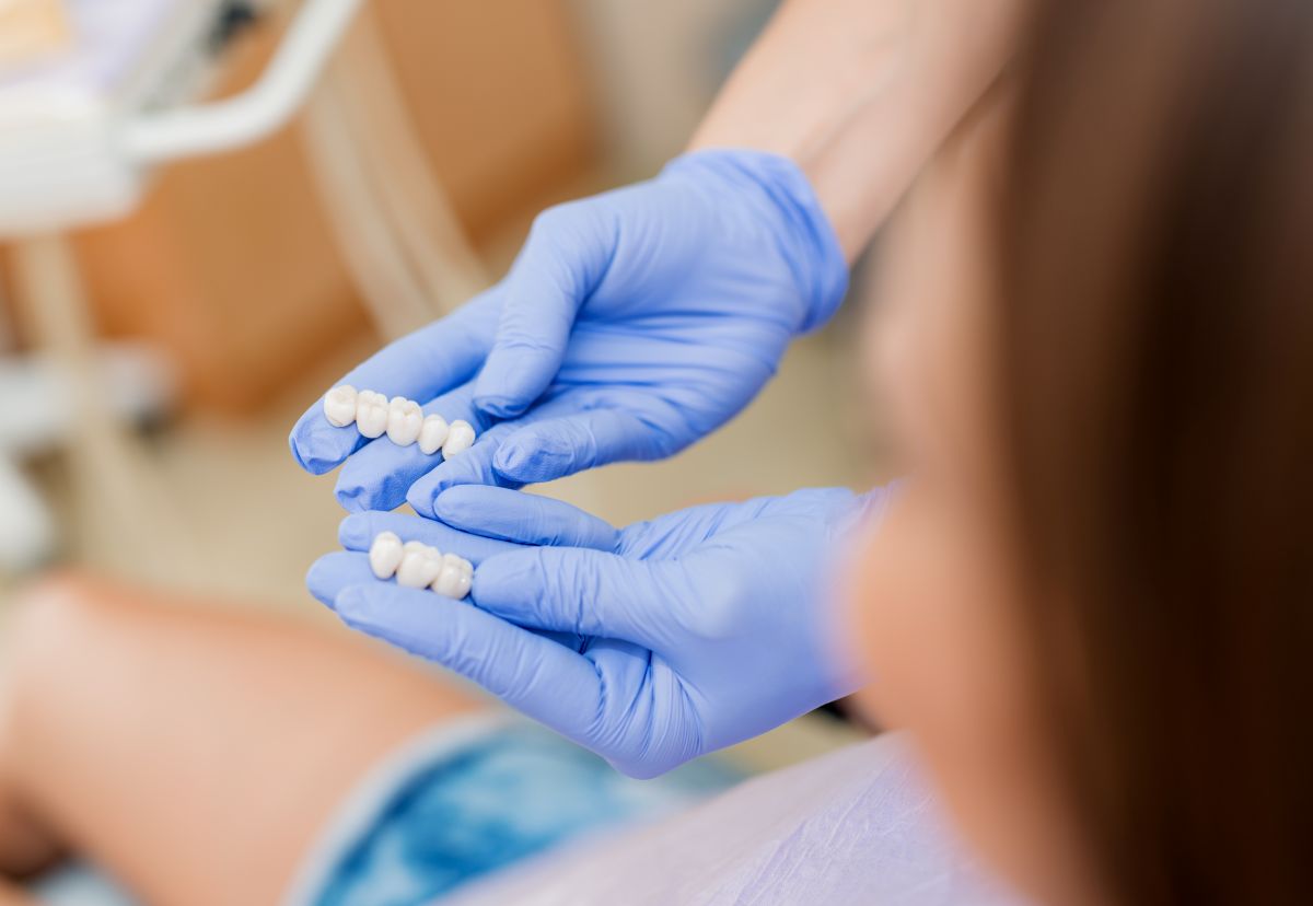 Dentist holding a custom dental bridge at Bay Area Dental Fremont CA