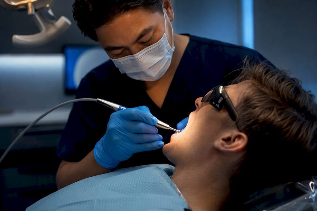 Dentist performing minimally invasive laser cavity treatment