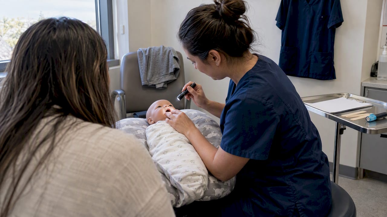 Clinician observes infant's lip during feeding